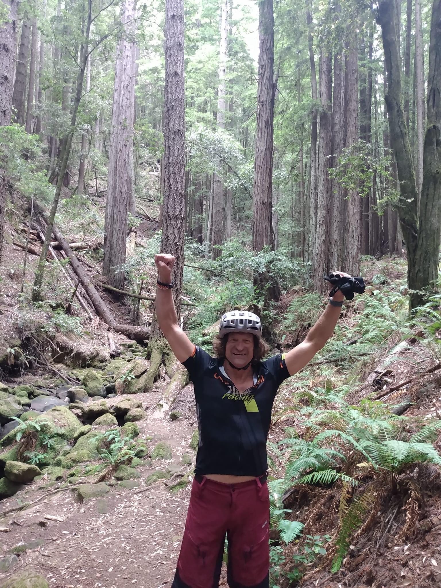 Arms raised on a forest trail
