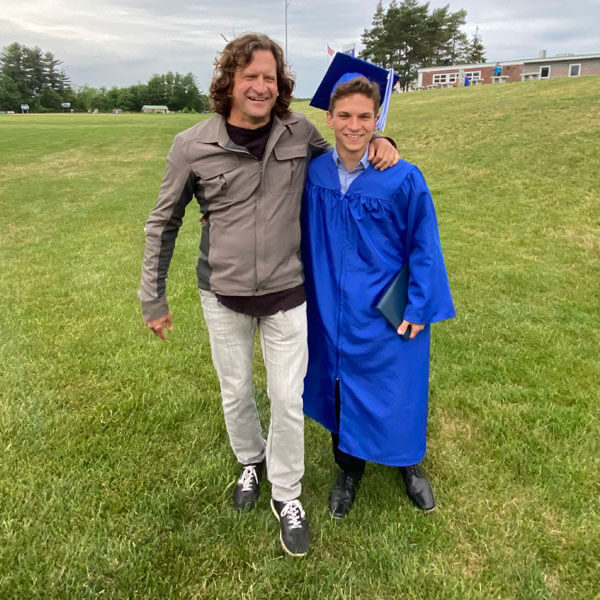 Standing with a high school graduate on a grass field